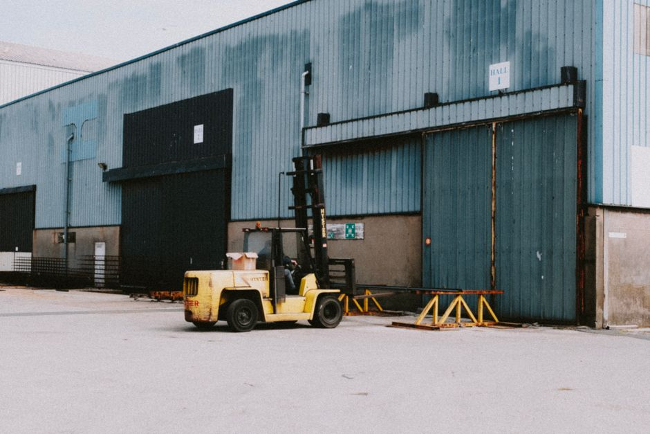 A commercial loading dock area with open bay doors and warehouse traffic in an active facility.