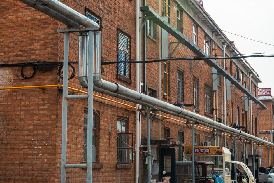 An industrial utility corridor with wall penetrations, conduit runs, and building infrastructure inside a commercial facility.