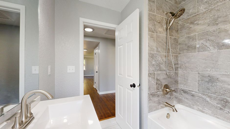 A primary suite view showing the connection between bedroom, bathroom, and walk-in closet through adjoining doorways.
