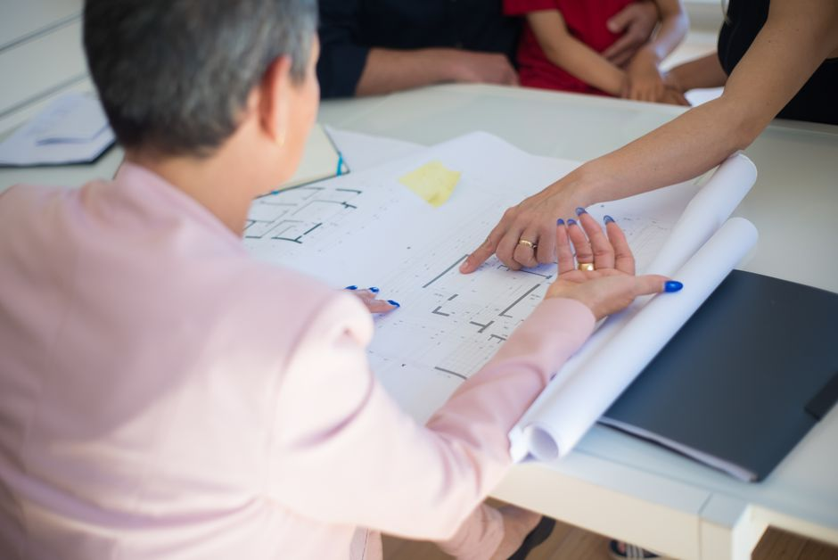 A homeowner and contractor reviewing kitchen renovation plans together at a table.