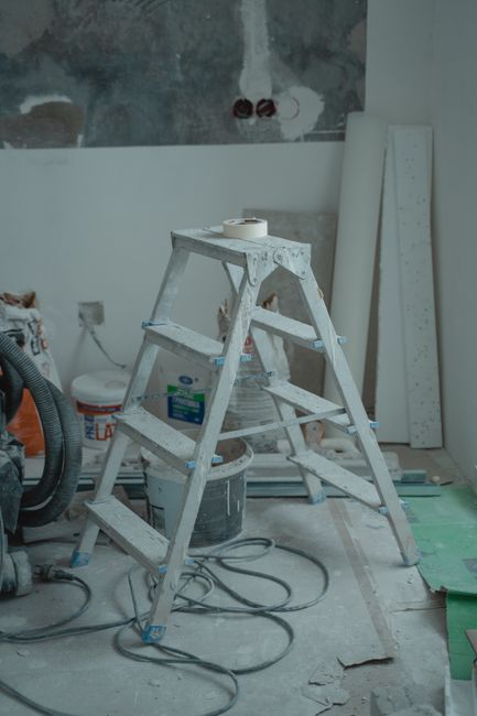 A bathroom mid-demolition with exposed framing and construction debris visible.