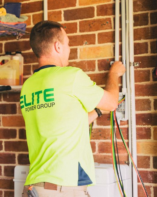 A contractor inspecting a home's electrical panel during a preconstruction evaluation.