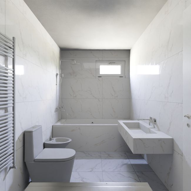 Modern bathroom shower with large-format wall tile, minimal grout lines, and a calm neutral finish.