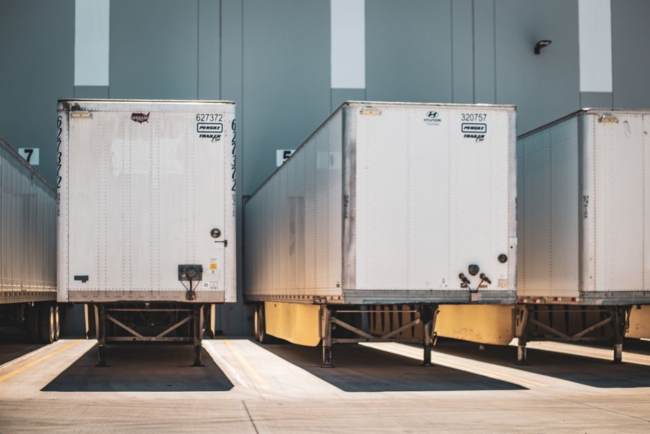 Clean warehouse receiving area with pallets staged near loading dock doors.