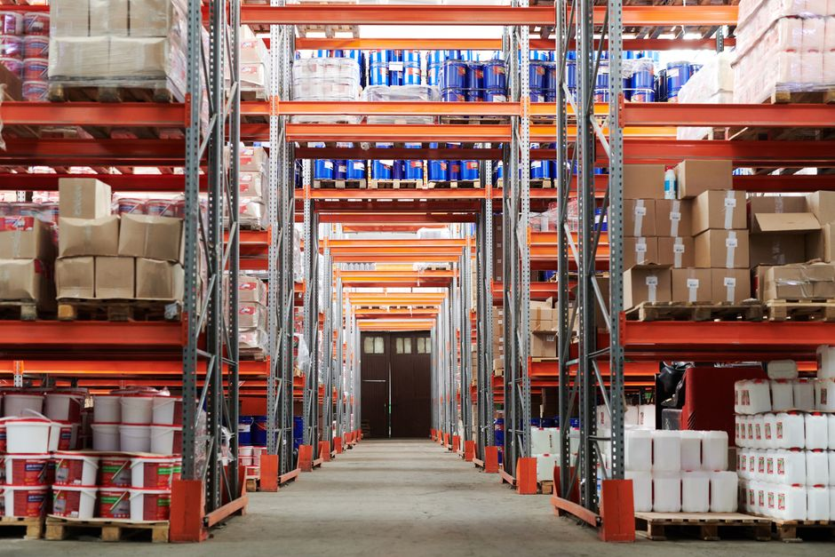 Long warehouse wall run with open floor space and structural edges where pests could travel unseen.