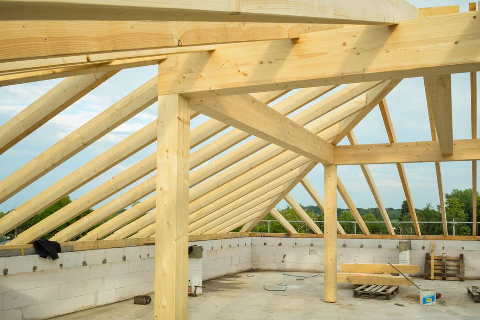 A house interior during renovation with exposed framing, opened walls, and visible structural work.