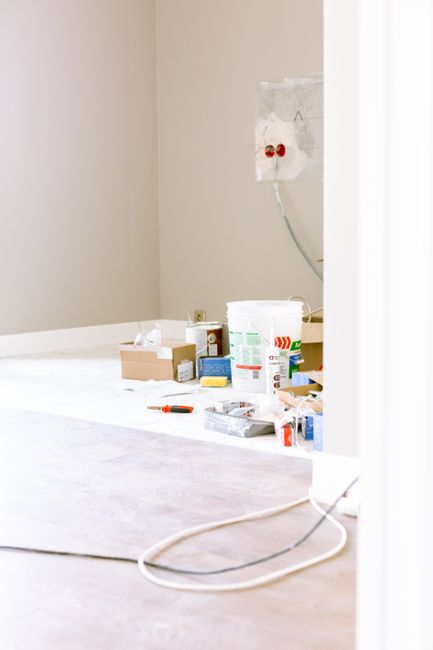 An older home's interior opened up during renovation, showing exposed framing, wiring, and plumbing.