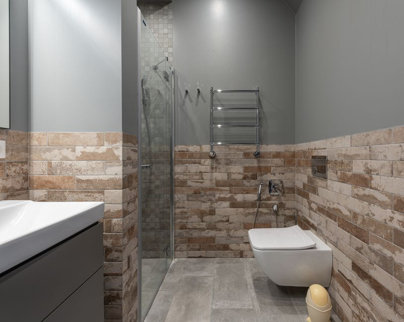 A compact modern bathroom with updated shower tile, vanity, and lighting in a tight footprint.