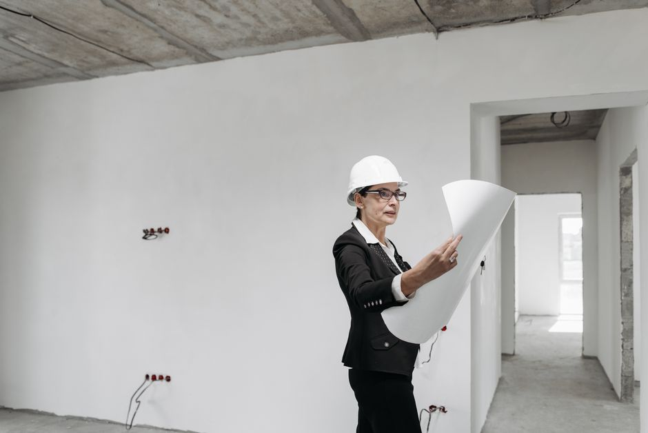 Contractor and homeowner reviewing renovation plans and estimate documents together.