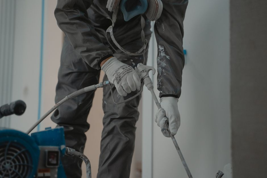 A restoration technician carefully cleaning soot residue from an interior wall.