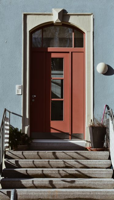 Contemporary front entry with a glass front door and sidelights bringing daylight into the interior.