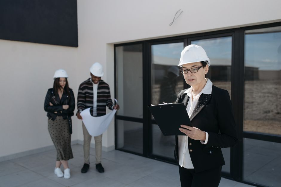 Homeowners reviewing custom home plans with a builder or architect at a meeting table.