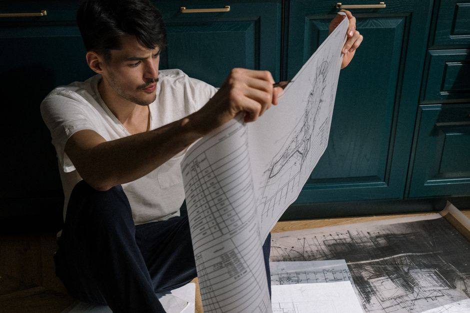 An architect or builder reviewing construction drawings and permit-related documents.