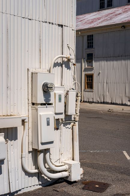 An electrician inspecting or upgrading an electrical panel in an older home.