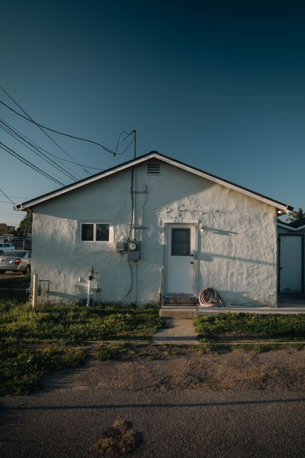 A single-story home with a rear ground-level addition under construction in the backyard.