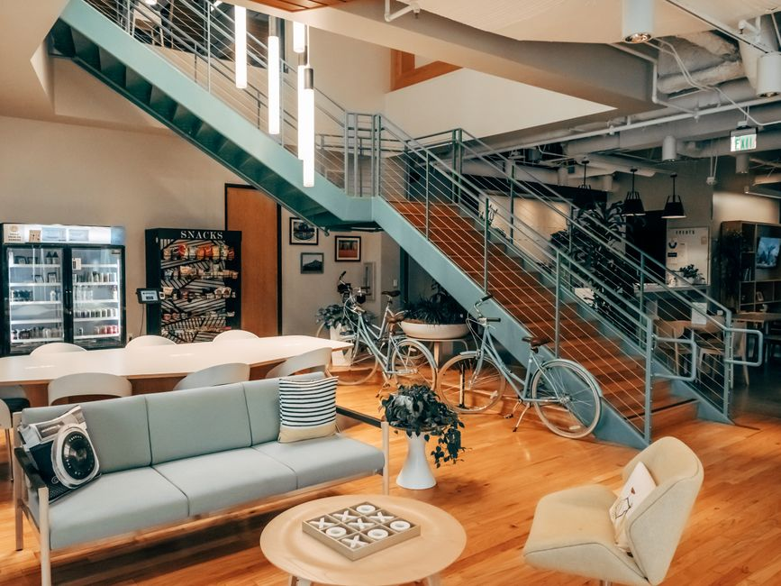 A modern office with a small collaboration area, shared table, and adjacent work zones.