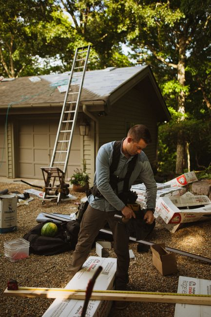 A roofing contractor reviewing a residential roof inspection with a homeowner outdoors.