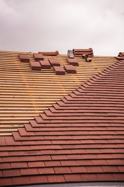 Close view of a roof vent pipe with flashing and rubber boot on a shingled roof.