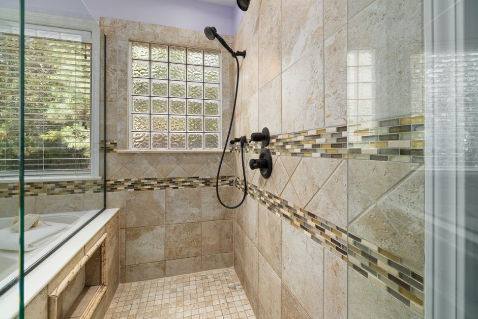 A bathroom shower under renovation with exposed floor, drain area, and waterproofing work in progress.