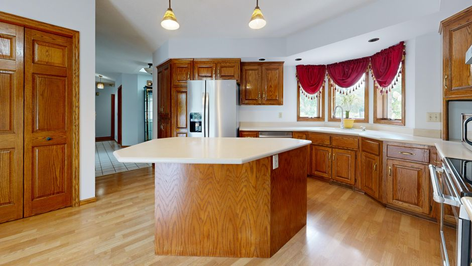 A modern open kitchen with an island, clear walkways, and distinct prep and cleanup zones.