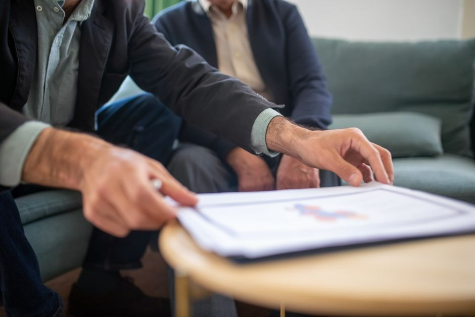 A small business owner reviewing contract and insurance paperwork at a desk.