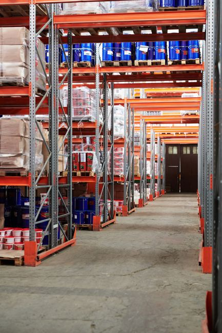 Interior of a commercial warehouse showing a loading dock area and long wall corridor where rodent pressure may develop.
