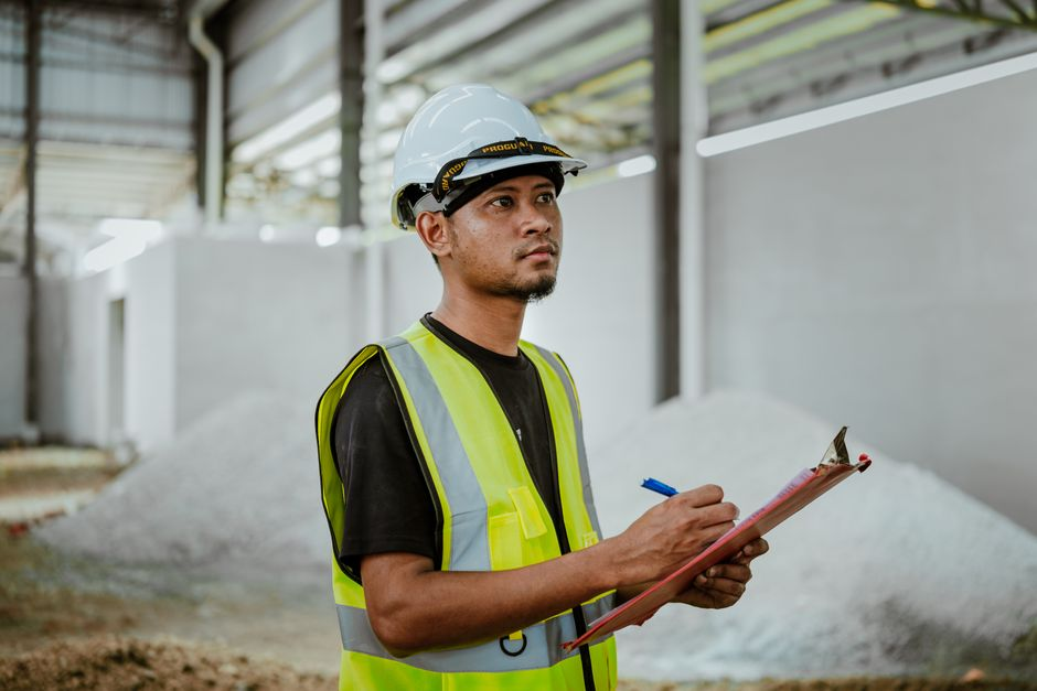 A facility manager or operations lead walking through an industrial facility during an inspection.
