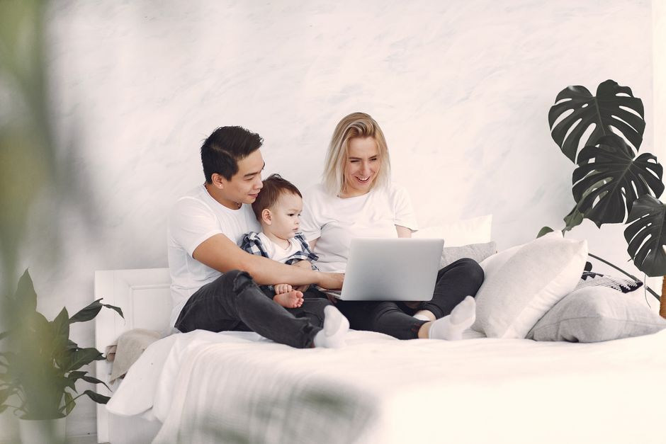 A couple planning finances together with notes, a calendar, and household documents spread out on a table.