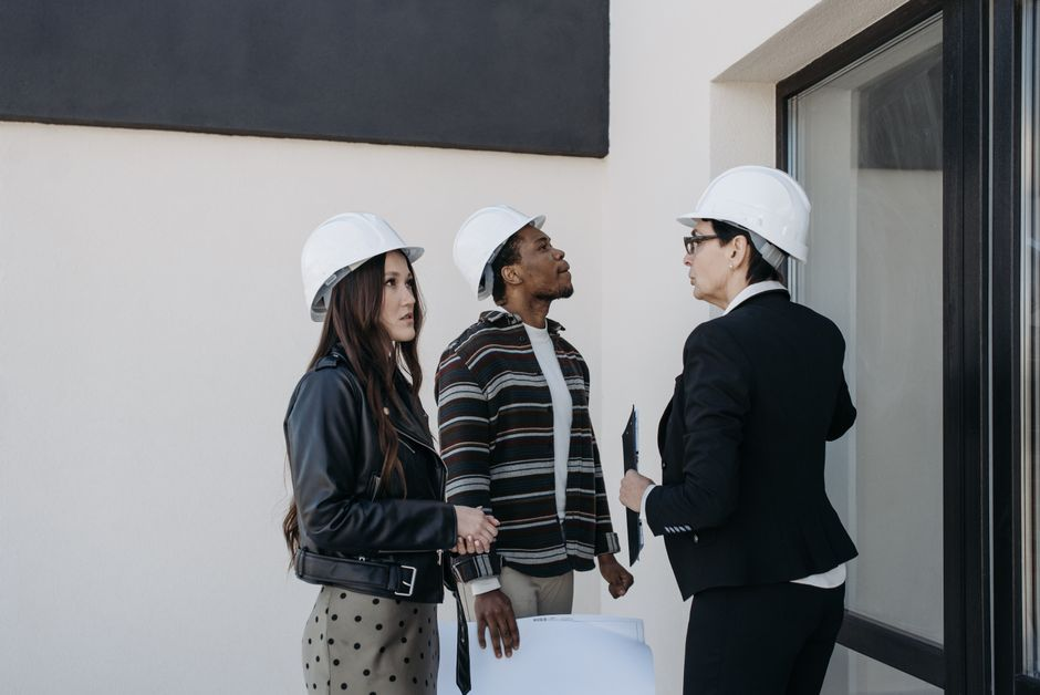 A homeowner meeting with a contractor over plans and notes during a home addition consultation.