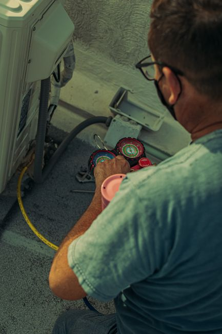 A technician using a moisture meter on an interior wall during a residential water damage assessment.