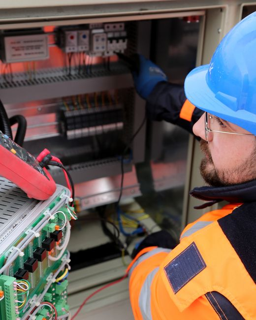 Residential renovation scene showing utility or inspection work, such as an electrical panel being checked on site.