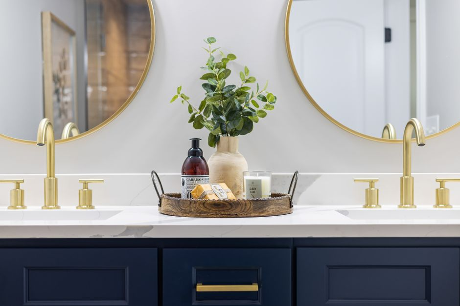 A well-planned luxury bathroom vanity with double sinks, layered mirror lighting, and integrated storage drawers.