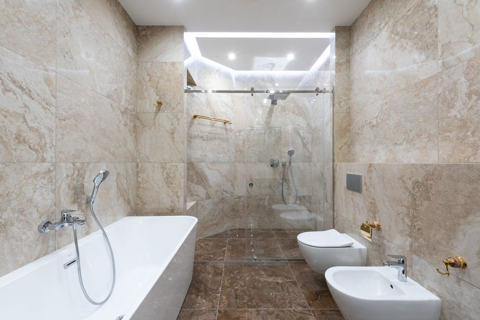 A curbless walk-in shower with a seamless floor transition, glass enclosure, and minimalist tile detailing.