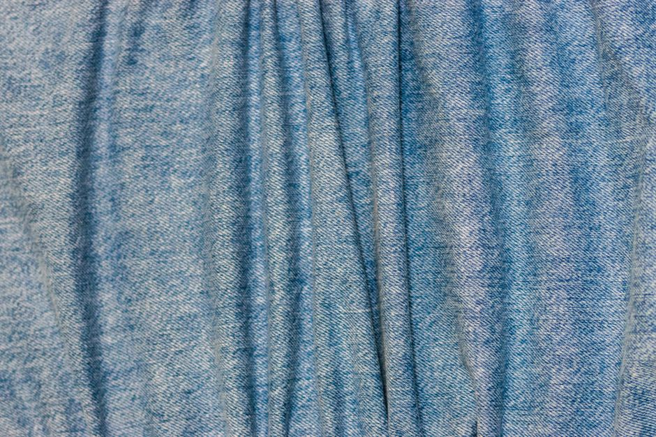 Soft jersey knit fabric draped in loose folds on a sewing table.
