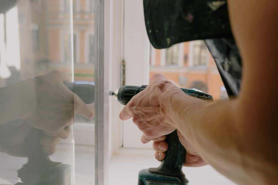 Technician applying or inspecting privacy film on an existing glass panel.