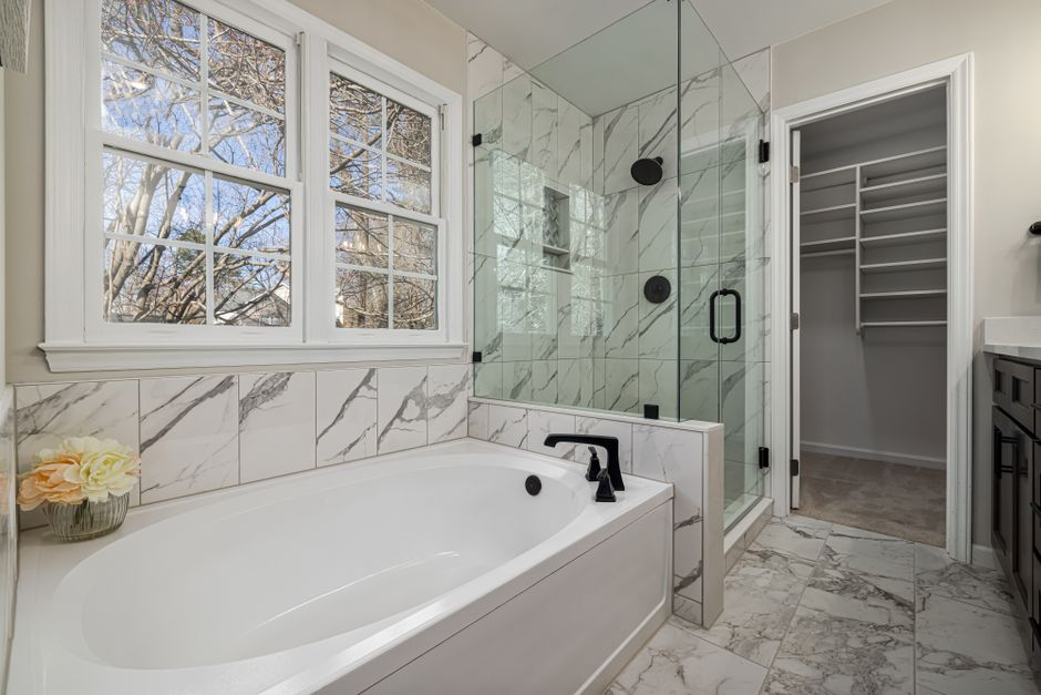 A bright modern bathroom with a large glass window and clean minimal finishes.