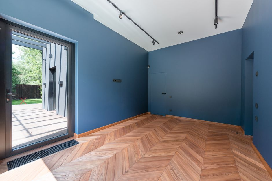 A modern home entry with a glass front door and narrow sidelights bringing light into the foyer.