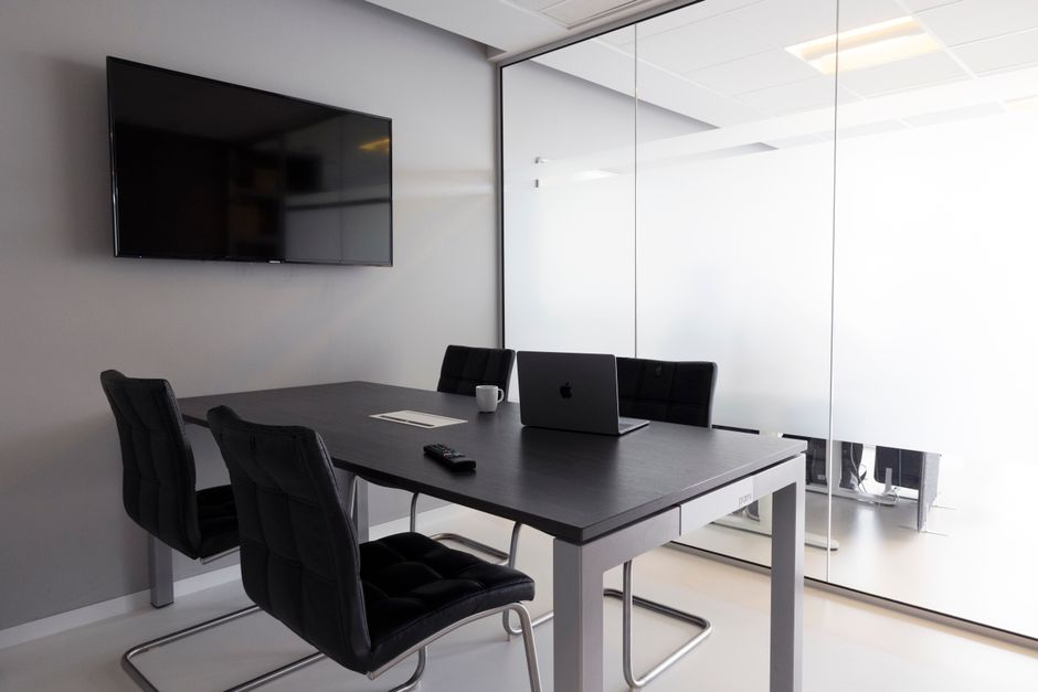 A contemporary home office separated by a clear interior glass partition.