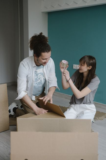 People standing in a rental apartment with moving boxes and keys in hand.