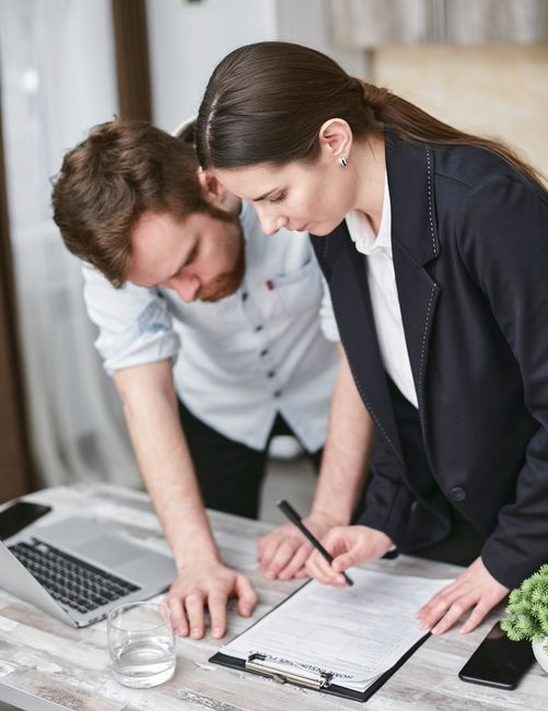 A homeowner reviewing estimate paperwork and contract documents at a kitchen table.