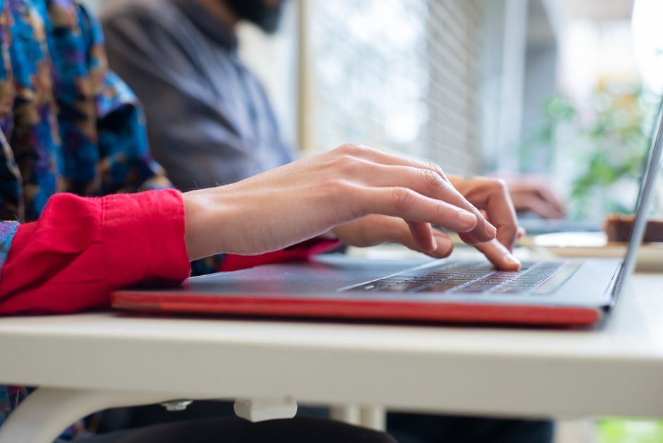 A small business employee looking at a suspicious email on a laptop in an office.