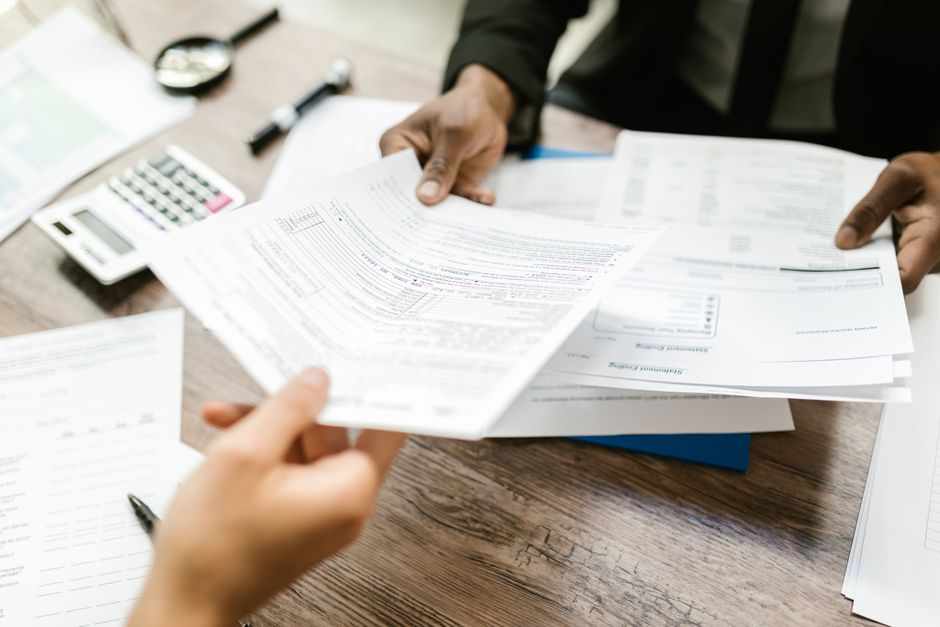 A homebuying couple sitting at a table reviewing insurance and closing documents together.