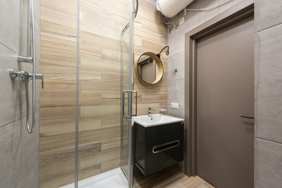 A compact modern bathroom with a wall-mounted floating vanity and visible open floor beneath it.
