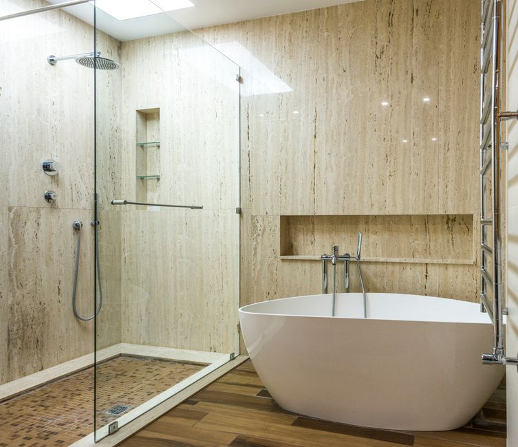 A small bathroom with a walk-in shower enclosed by clear glass panels and minimal visual barriers.