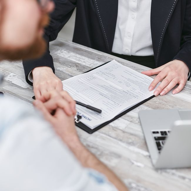 A small business owner reviewing and signing business paperwork at a desk.
