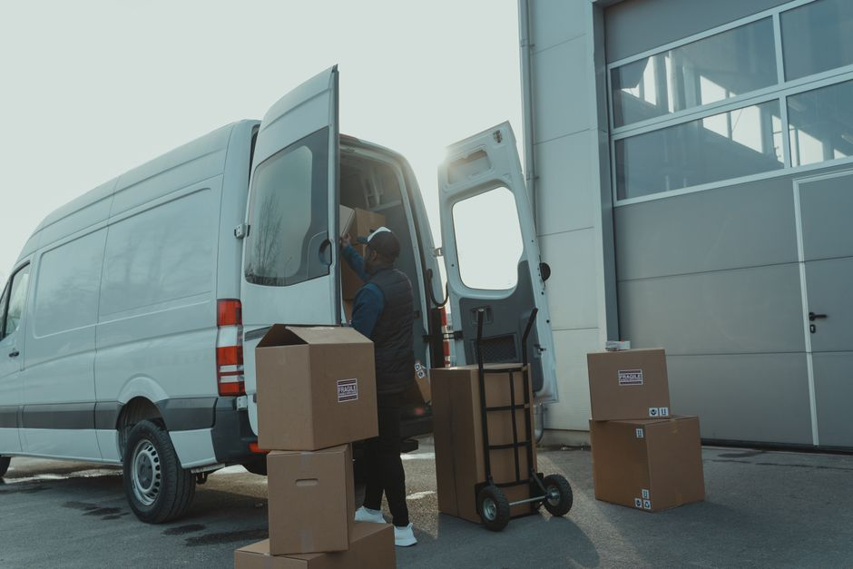 A small business owner standing beside a work van used for daily operations.