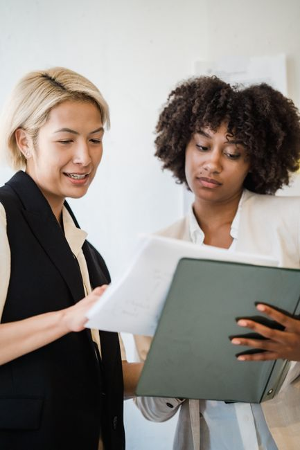A business owner reviewing insurance or risk documents with an advisor at a desk.