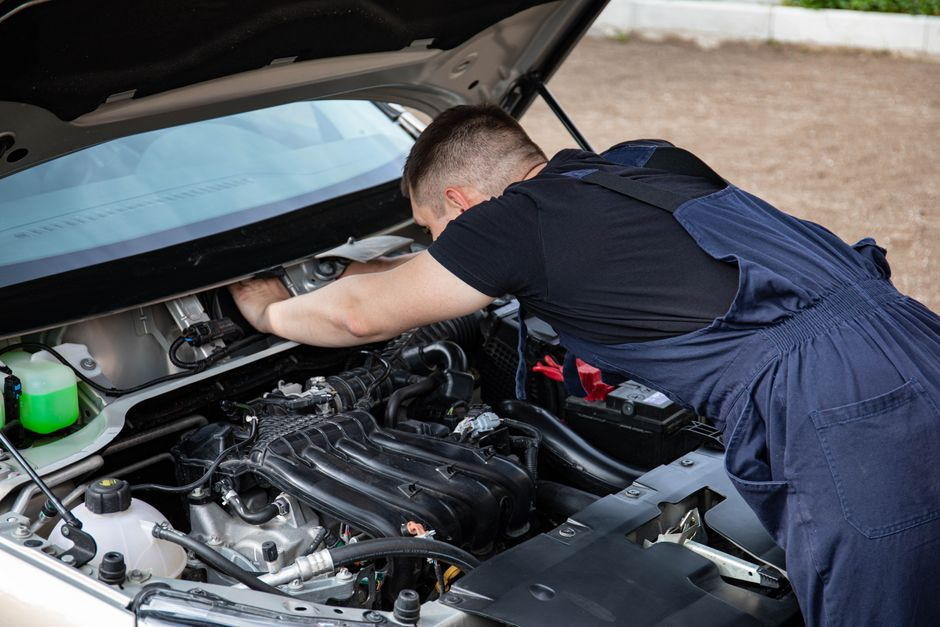 A dealership staff member inspecting a used vehicle during an appraisal.