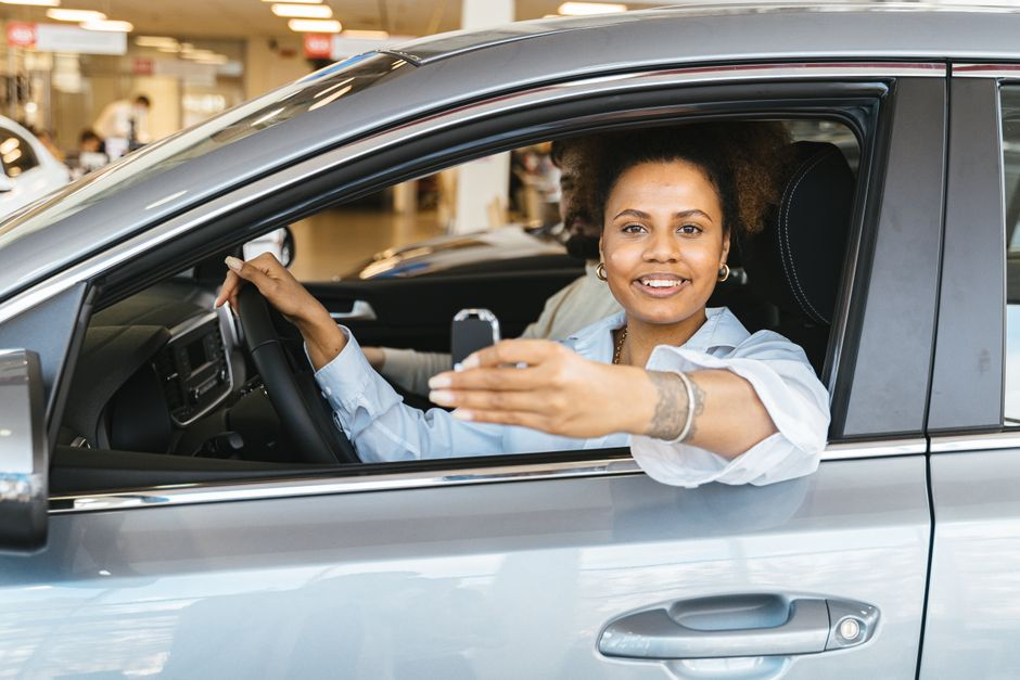 A customer handing over car keys while discussing a trade-in at a dealership.
