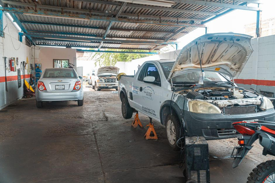 A commercial truck in a service bay with a mechanic inspecting it for maintenance or repair.